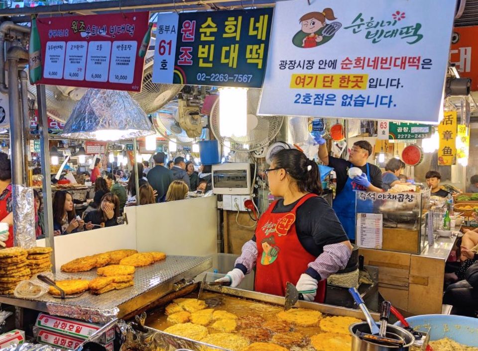 a vendor selling food at Gwangjang Market - unique things to do in Seoul at night