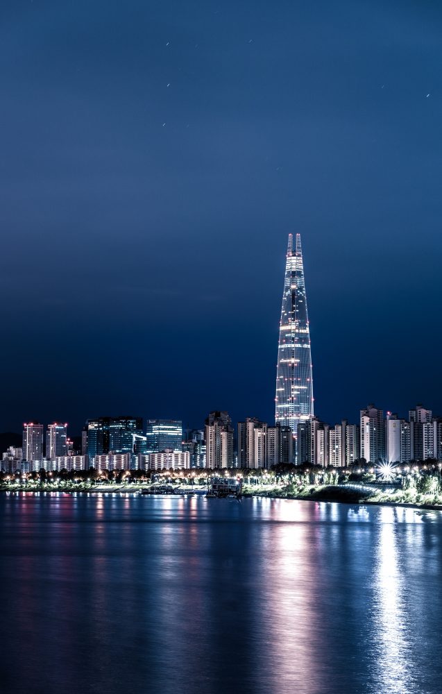 lotte world tower next to the Han River and apartment buildings lit up in seoul at night
