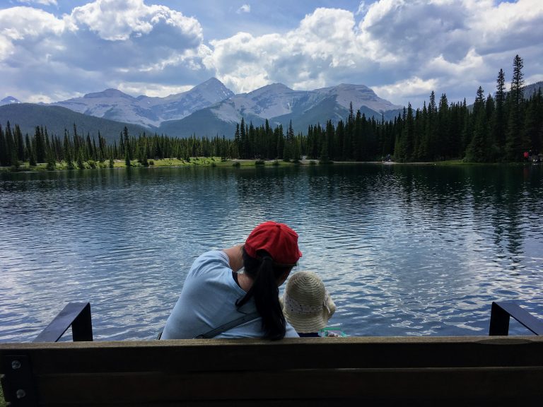 Mom and daughter looking at the forget me not pond in kananaski alberta