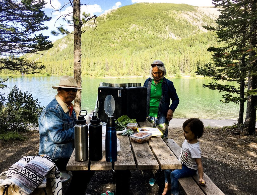 family having a bbq and picnic at forget me not pond in kananaskis