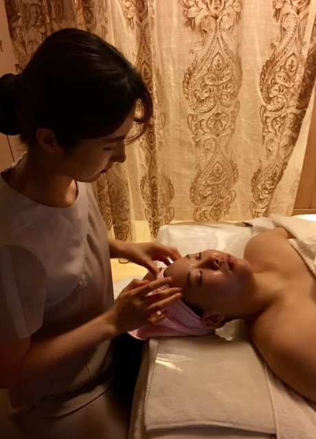 An aesthetician performing double cleansing during a facial in Korea.
