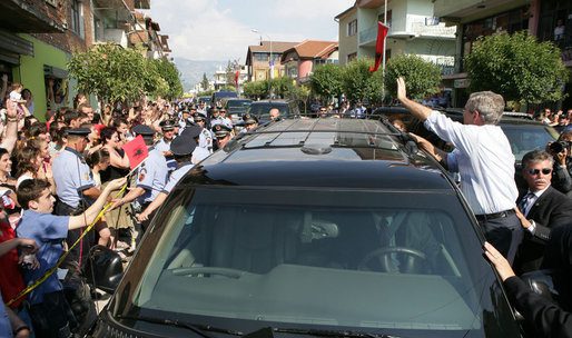 George W. Bush waving at crowds from a car in Fushe Kruje Albania