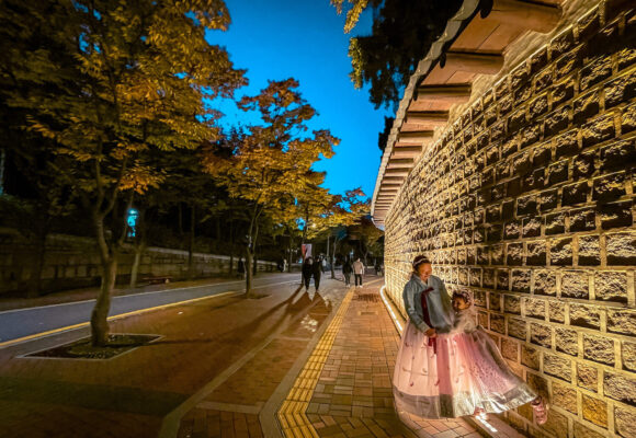 wearing hanboks outside deoksugung stone wall road